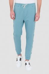 GUESS Turkusowe dresowe spodnie New Arlo. Niebieskie spodnie dresowe męskie Guess, z aplikacjami, z dresówki. W wyprzedaży za 259.99 zł.