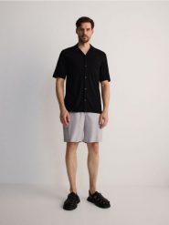 Szorty relaxed jogger - szary. Szare szorty męskie Reserved, z bawełny, bez kołnierzyka. W wyprzedaży za 69.99 zł.