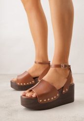 Brązowe Sandały na Koturnie i Platformie Ozdobione Nitami Rhethe. Brązowe sandały damskie Born2be, bez wzorów, z jeansu, bez obcasa, na koturnie. Za 99.99 zł.