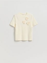 T-shirt z kwiatową aplikacją - kremowy. Białe t-shirty damskie Reserved, l, z aplikacjami, z bawełny, bez kołnierzyka. Za 79.99 zł.