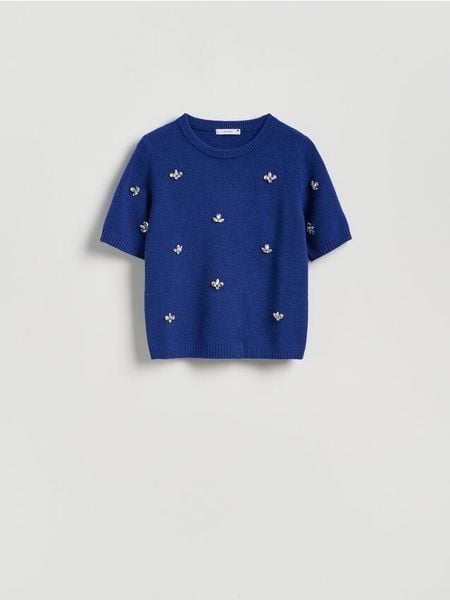 Sweter z błyszczącą aplikacją - niebieski. Niebieskie swetry klasyczne damskie Reserved, l, z dzianiny, bez kołnierzyka. W wyprzedaży za 79.99 zł.