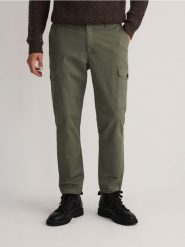 Bawełniane spodnie cargo - ciemnozielony. Zielone spodnie materiałowe męskie Reserved, bez wzorów, z bawełny. W wyprzedaży za 79.99 zł.