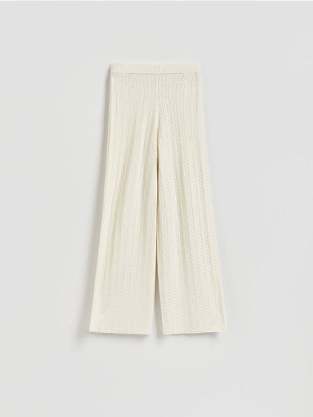 Dzianinowe spodnie - kremowy. Białe spodnie materiałowe damskie Reserved, bez wzorów, z dzianiny. Za 139.99 zł.