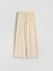 Ażurowe spodnie z bawełną - kremowy. Białe spodnie materiałowe damskie Reserved, w ażurowe wzory, z bawełny. Za 139.99 zł.