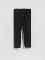 Spodnie Slim fit - czarny. Czarne spodnie materiałowe męskie Reserved, bez wzorów, z bawełny. W wyprzedaży za 99.99 zł.