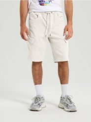 Szorty jeansowe jogger - kremowy. Białe szorty męskie Sinsay, z jeansu, bez kołnierzyka. W wyprzedaży za 45.99 zł.
