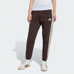 Spodnie Stadium Three Stripes Regular. Brązowe spodnie materiałowe damskie Adidas, bez wzorów, z bawełny, klasyczne, z standardowym stanem. Za 279.00 zł.
