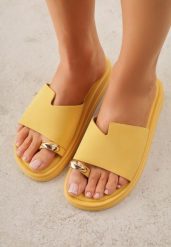 Żółte Klapki Typu Japonki z Metaliczną Ozdobą Samrina. Żółte klapki damskie Born2be, z aplikacjami, z jeansu, bez obcasa, na płaskiej podeszwie. Za 79.99 zł.