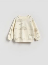 Bluza z nadrukiem - złamana biel. Bluzy i bluzki niemowlęce Reserved, bez wzorów, z bawełny, bez ramiączek, bez kaptura. Za 39.99 zł.