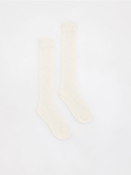 Ażurowe skarpetki - złamana biel. Skarpetki damskie Reserved, w ażurowe wzory. W wyprzedaży za 22.99 zł.