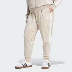 Spodnie Dresowe Essentials 3-Stripes (Dla Sylwetek Plus Size). Białe spodnie dresowe damskie Adidas, plus size, z dresówki, na fitness i siłownię. Za 219.00 zł.