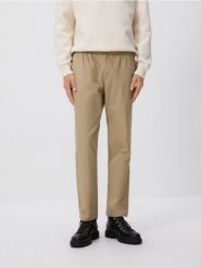 Spodnie jogger slim - beżowy. Brązowe spodnie materiałowe męskie Reserved, bez wzorów, z bawełny. W wyprzedaży za 69.99 zł.