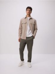 Spodnie regular fit - jasny zielony. Zielone spodnie materiałowe męskie Reserved, bez wzorów, z dzianiny. W wyprzedaży za 69.99 zł.