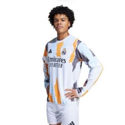 Koszulka przedmeczowa Real Madrid 2024/25. Białe t-shirty sportowe męskie Adidas, bez ramiączek, do piłki nożnej. Za 351.60 zł.