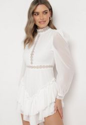 Biała Rozkloszowana Sukienka Kombinezon Mini z Falbankami Gilha. Białe kombinezony damskie Born2be, m, z aplikacjami, z koronki, bez kołnierzyka, bez ramiączek. Za 159.99 zł.