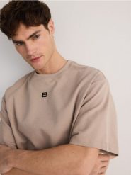 T-shirt boxy z nadrukiem - beżowy. Brązowe t-shirty męskie Reserved, l, bez wzorów, z dzianiny, bez kołnierzyka. W wyprzedaży za 49.99 zł.