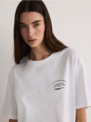 T-shirt oversize z nadrukiem - biały. Białe t-shirty damskie Reserved, l, bez wzorów, z bawełny, bez kołnierzyka. W wyprzedaży za 25.99 zł.