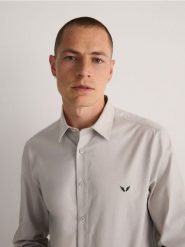 Koszula slim fit z haftem - beżowy. Brązowe koszule męskie Reserved, l, bez wzorów, z bawełny, bez kołnierzyka, bez ramiączek. W wyprzedaży za 39.99 zł.