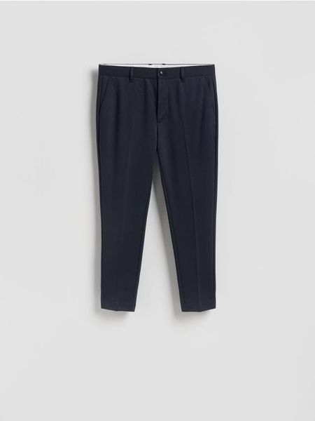 Spodnie chino slim fit - granatowy. Niebieskie spodnie materiałowe męskie Reserved, bez wzorów, z dzianiny. Za 139.99 zł.