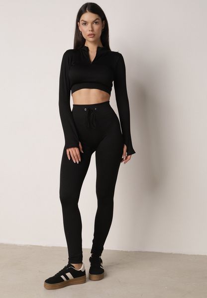Czarny Komplet Sportowy Top z Wycięciem na Kciuk i Spodnie z Wiązaniem Tidrine. Czarne spodnie sportowe damskie Born2be, na fitness i siłownię. Za 79.99 zł.