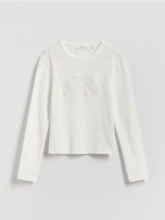 Koszulka z wypukłą aplikacją - złamana biel. Koszulki dziewczęce Reserved, z aplikacjami, z bawełny, bez ramiączek. Za 39.99 zł.