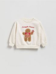 Bluza ze świąteczną aplikacją - złamana biel. Bluzy i bluzki niemowlęce Reserved, z aplikacjami, z bawełny, bez ramiączek, bez kaptura. Za 55.99 zł.