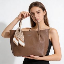 Torebka damska Rieker, ze skóry ekologicznej o prostej eleganckiej formie z ozdobną apaszką przy uchwycie wygodna do noszenia w dłoni i na ramieniu,. Brązowe shopper bag damskie Rieker, bez wzorów, ze skóry ekologicznej, na ramię, bez dodatków. Za 279.00 zł.