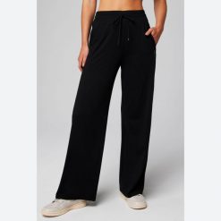Damskie spodnie z szerokimi nogawkami Fabletics Cloud Jersey. Czarne spodnie sportowe damskie FABLETICS, s, z dresówki, na fitness i siłownię. Za 318.80 zł.