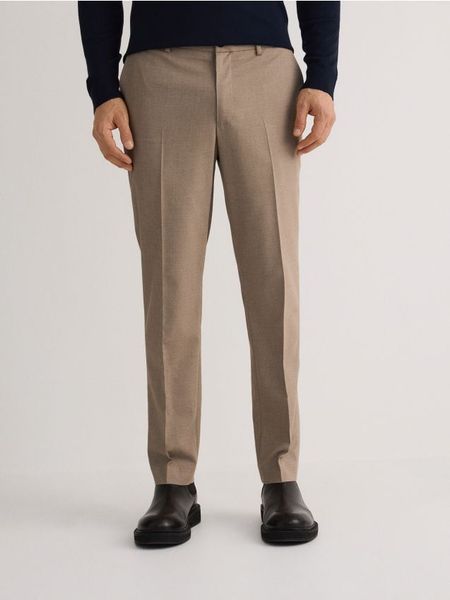 Spodnie chino slim z kantem - beżowy. Brązowe spodnie materiałowe męskie Reserved, bez wzorów, z tkaniny. W wyprzedaży za 59.99 zł.