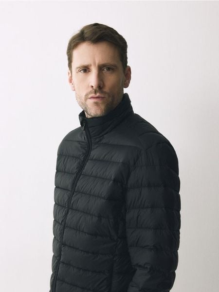 Puchowa kurtka z pokrowcem - czarny. Czarne kurtki męskie Reserved, l, bez wzorów, z puchu, bez kaptura. Za 299.99 zł.