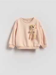Bluza z aplikacją 3d - złamana biel. Bluzy i bluzki niemowlęce Reserved, z aplikacjami, z bawełny, bez ramiączek, bez kaptura. Za 59.99 zł.