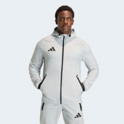 Kurtka piłkarska treningowa ADIDAS Tiro Travel 26. Brązowe kurtki damskie Adidas, m, bez wzorów, z materiału, z kapturem. Za 229.99 zł.