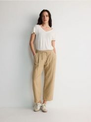 Spodnie jogger z muślinu - beżowy. Brązowe spodnie materiałowe damskie Reserved, bez wzorów, z bawełny. W wyprzedaży za 49.99 zł.