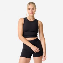 Koszulka fitness damska Domyos crop top. Czarne bluzki sportowe damskie DOMYOS, l, z elastanu, bez kołnierzyka, bez ramiączek. Za 69.99 zł.