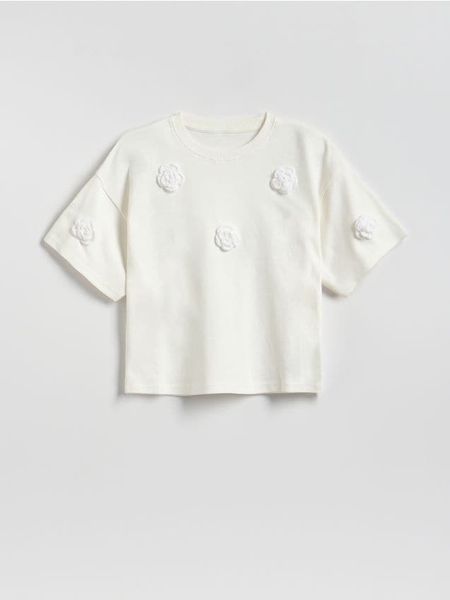 T-shirt z aplikacją - złamana biel. Koszulki dziewczęce Reserved, z aplikacjami, z bawełny, bez ramiączek. Za 39.99 zł.
