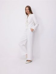 Szerokie spodnie z dekoracyjnymi guzikami - złamana biel. Spodnie materiałowe damskie Reserved, bez wzorów, z tkaniny. W wyprzedaży za 119.99 zł.