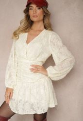 Beżowa Sukienka z Koronki o Taliowanym Fasonie z Kopertową Górą Nelabine. Brązowe sukienki damskie Renee, na spotkanie biznesowe, na wiosnę, m, bez wzorów, z koronki, eleganckie, bez kołnierzyka, bez ramiączek, mini, kopertowe. Za 139.99 zł.