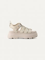UGG Skórzane sandały "Cora" w kolorze kremowym rozmiar: 38. Brązowe sandały damskie Ugg, bez wzorów, z materiału, bez obcasa, na koturnie. Za 555.15 zł.