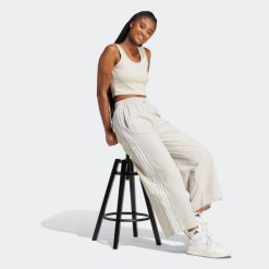 Spodnie damskie ADIDAS Essentials. Szare spodnie materiałowe damskie Adidas, bez wzorów, z poliamidu, eleganckie. Za 219.99 zł.