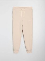 Spodnie jogger slim fit - beżowy. Brązowe spodnie materiałowe męskie Sinsay, bez wzorów, sportowe. Za 49.99 zł.