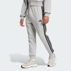 Spodnie Essential 3-Stripes French Terry. Czarne spodnie sportowe męskie Adidas, z materiału. W wyprzedaży za 137.40 zł.