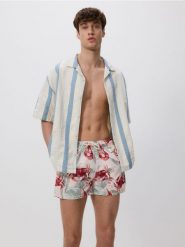 Wzorzyste szorty plażowe - intenstywna czerwień. Czerwone szorty męskie Reserved, z tkaniny, bez kołnierzyka. W wyprzedaży za 49.99 zł.