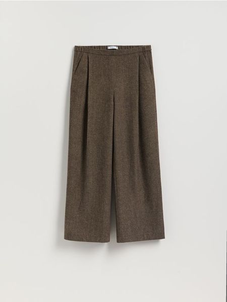 Szerokie spodnie z zakładkami - brązowy. Brązowe spodnie materiałowe damskie Reserved, bez wzorów, z tkaniny. Za 159.99 zł.