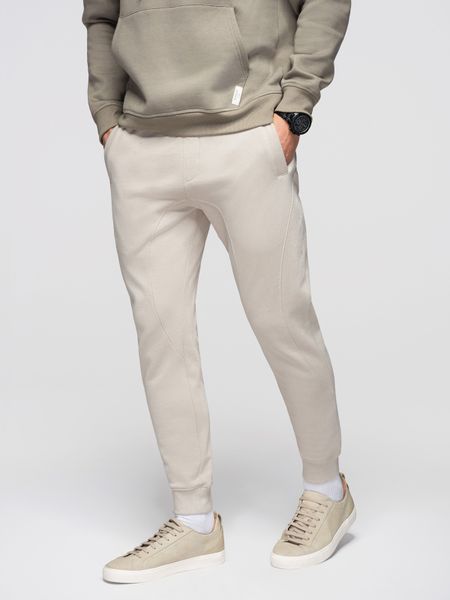 Spodnie męskie dresowe ze ściągaczem przy nogawce BASIC jogger - jasnobeżowe V1 - Rozmiar: XL. Szare spodnie dresowe męskie Ombre Clothing, z aplikacjami, z bawełny. W wyprzedaży za 118.99 zł.