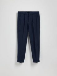 Spodnie chino slim z lnem - granatowy. Niebieskie spodnie materiałowe męskie Reserved, bez wzorów, z bawełny. W wyprzedaży za 129.99 zł.