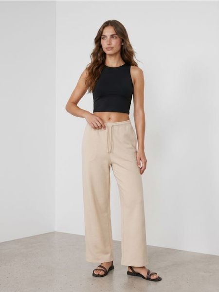Spodnie dresowe wide leg - beżowy. Brązowe spodnie sportowe damskie Sinsay, l, z dresówki, na fitness i siłownię. Za 39.99 zł.