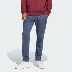 Spodnie Manchester United Seasonal. Niebieskie spodnie dresowe męskie Adidas, bez wzorów, z dresówki. Za 299.00 zł.