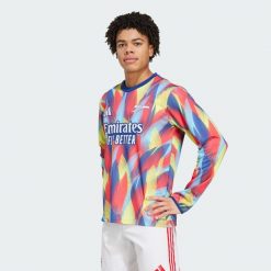 Koszulka Arsenal 25/26 Pre-Match Warm. Czerwone t-shirty sportowe męskie Adidas, xl, z materiału, bez ramiączek, do piłki nożnej. Za 456.50 zł.