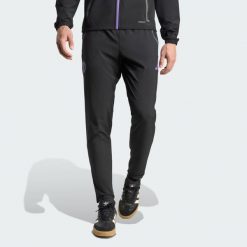 Spodnie Manchester United Tiro 25 Competition Vis Tech Travel. Czarne spodnie materiałowe męskie Adidas, z aplikacjami, z elastanu, klasyczne, z standardowym stanem. Za 329.00 zł.