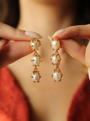 Pierres de Jade Pozłacane kolczyki-wkrętki z perłami rozmiar: onesize. Białe kolczyki damskie Pierres de Jade, z perłą, pozłacane. Za 39.99 zł.